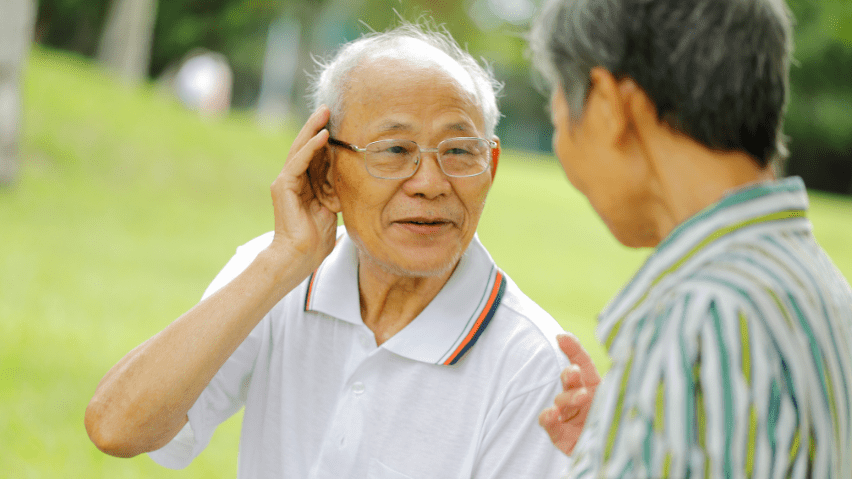Senior man cupping his ears.